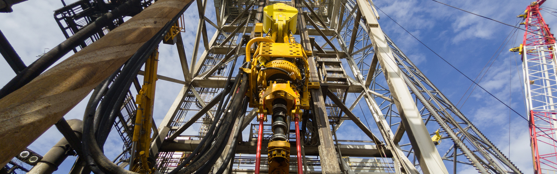Driller floor of an offshore drilling rig with top drive, pipe handler and drawwors