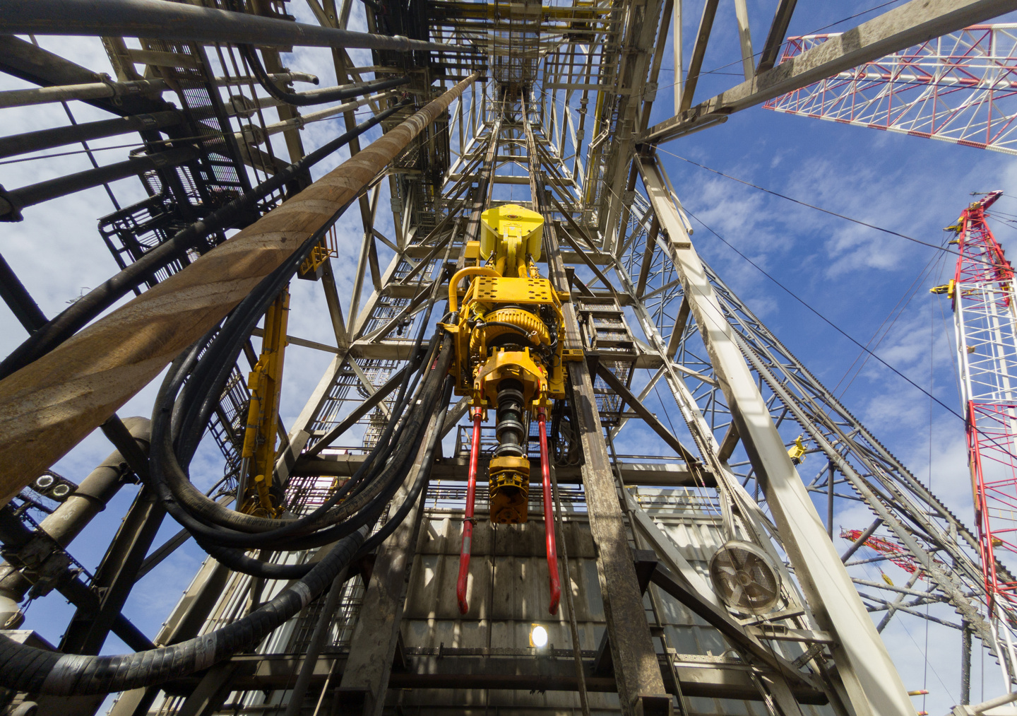 Driller floor of an offshore drilling rig with top drive, pipe handler and drawwors